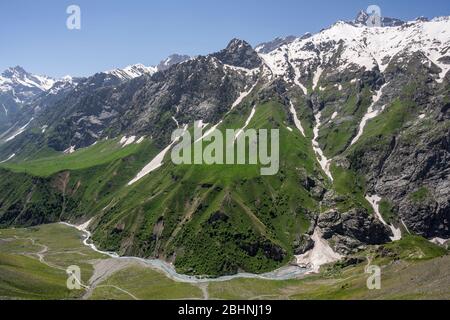 Mountains at Sughd at the end of the tunnel Takfon-Kalon in Tadzjikistan with snow and a river in the valley. Stock Photo