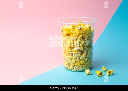 Popcorn on a colored background. Minimal food concept. Entertainment, film and video content. Aesthetics 80s and 90s concept Stock Photo