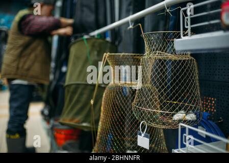 Male angler choosing net in fishing shop Stock Photo
