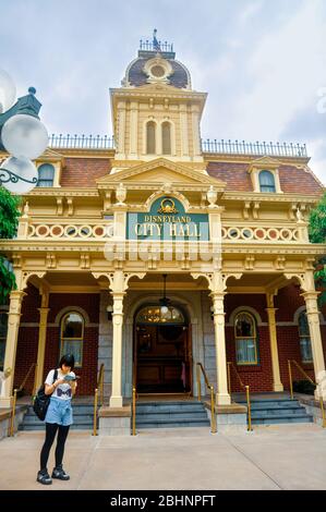 Lantau Island / Hong Kong - June 14 2013: One young woman tourist standing in front of the Disneyland City Hall. Stock Photo