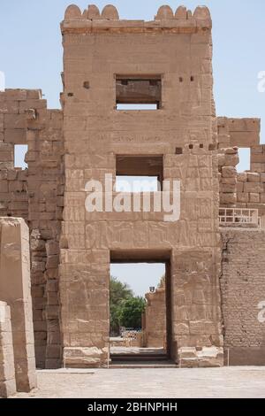 Hieroglypic carvings on wall at the entrance gate to ancient egyptian temple of Medinat Habu in Luxor Stock Photo