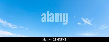 Clear blue sky with small white clouds as background, panoramic view of sky Stock Photo