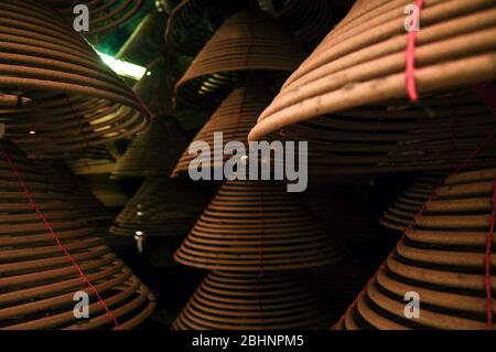 Temple interior Large spiral incense cones hanging from roof Stock Photo