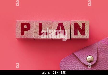 PLAN word made with building blocks on pink and small wallet. Financial planning finace management concept Stock Photo