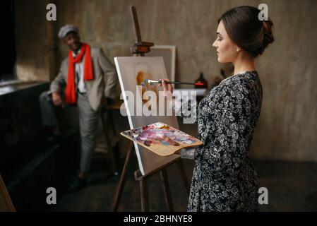 Female portrait painter and male model in studio Stock Photo