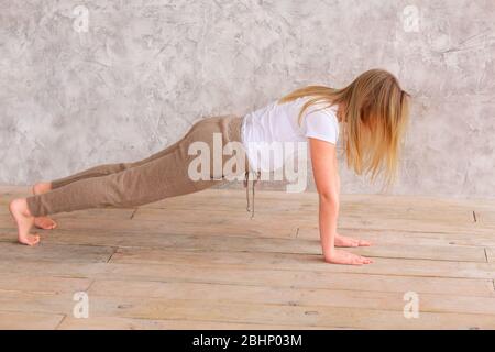 Tennage girl doing fitness gymnastics at home. Gymnastics video tutorial. Gymnastic exercises. Children's activity in quarantine during coronavirus pa Stock Photo