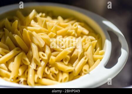 cooked italian penne rigate macaroni pasta draining Stock Photo