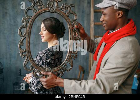 Portrait painter holds frame, female model Stock Photo