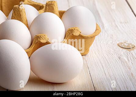 Eggs near the tray on white table closeup Stock Photo