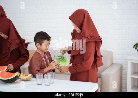 Asian mother pour syrup for child to break fast with family at home Stock Photo