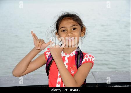 Nathdwara, Rajasthan, India, Asia - Jan. 23, 2014 - Seven years old Indian little cute girl standing acting as a playing flute Stock Photo