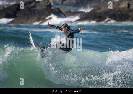 Spectacular action as a male surfer rides a wave at Fistral in Newquay in Cornwall. Stock Photo