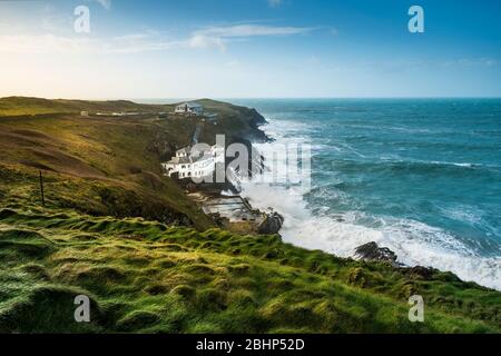 The large house known as Bakers Folly with the Lewinnick Lodge in the background on the rugged coast of Pentire Point East in Newquay in Cornwall. Stock Photo