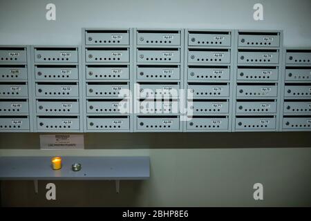 Bucharest, Romania - April 18, 2020: A candle lit by orthodox priests with the Holy Light is left at the mailboxes in a block of flats during the orth Stock Photo