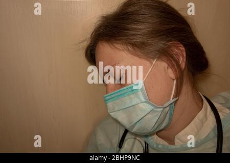 Doctor or nurse sleep. Coronavirus COVID-19 pandemic. Tired, exhausted woman in uniform is sleeping in hospital or clinic after hard duty. Female with Stock Photo