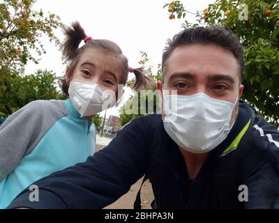 Father and daughter wearing FFP2 and N95 masks on the street. Stock Photo