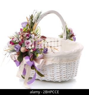 Hand made Easter basket Provence style decorated ribbons, flowers isolated on white background. Empty wicker basket in front of Stock Photo