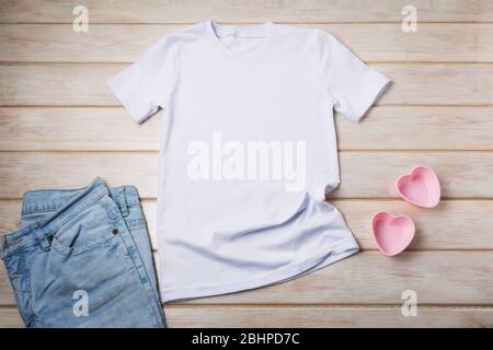 White women’s cotton T-shirt mockup with two pink heart cookies molds. Design t shirt template, tee print presentation mock up Stock Photo