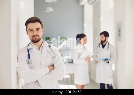 A male practicing doctor with a stethoscope against the background of a doctor at the clinic. Stock Photo