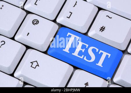 A keyboard with the word TEST on a blue enter key. Testing for COVID-19 or education concept. England, UK, Britain Stock Photo