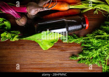 vitamin A in vegetable food, carrot, beet, pomegranate juice in wooden background. Detox Stock Photo