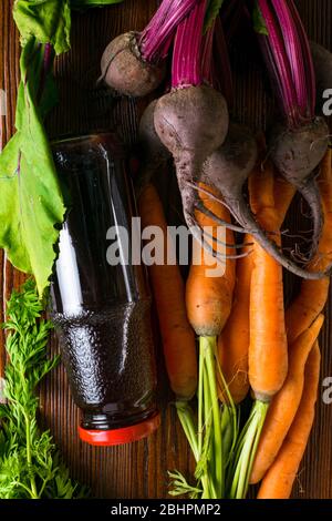 vitamin A in vegetable food, carrot, beet, pomegranate juice in wooden background. Detox Stock Photo