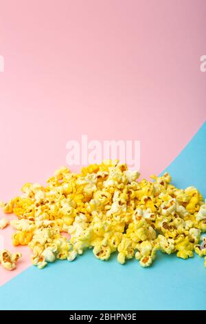 Popcorn on a colored background. Minimal food concept. Entertainment, film and video content. Aesthetics 80s and 90s concept Stock Photo