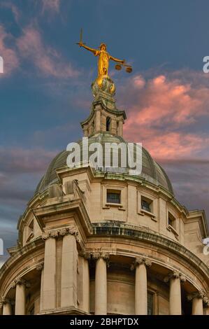 LONDON THE OLD BAILEY CRIMINAL COURT LADY JUSTICE STATUE IN GOLD ON TOP OF THE DOME WITH PINK CLOUDS AND BLUE SKY Stock Photo