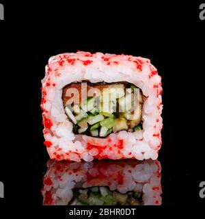 Sliced sushi with rice, salmon, cucumber, and caviar closeup on black background.. Stock Photo