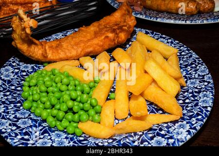 Fish and chips is a hot dish consisting of fried fish in batter served with chips. Classic fish and chips are one of Britain's national dishes. Stock Photo