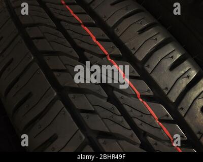 Black tyre treads with the safety red line Stock Photo