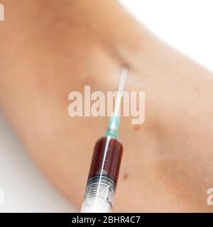 syringe in the arm patient drawing blood sample for blood test Stock Photo