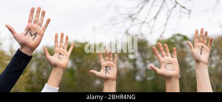 Word merci written on child hands outdoor Stock Photo