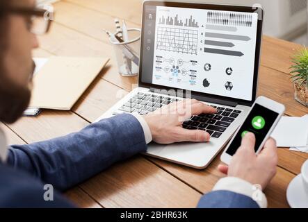 Entrepreneur analyzing graph on laptop at workplace Stock Photo