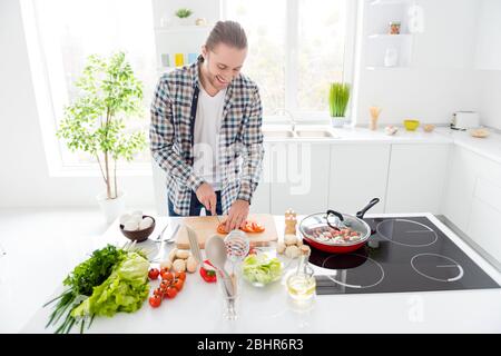 Portrait of his he nice attractive cheerful focused guy making fresh delicious meal dinner lunch luncheon snack spending weekend free time in modern Stock Photo