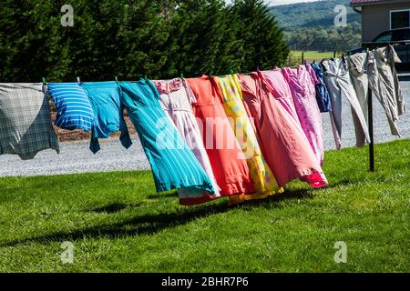 Colourful vintage style clothing drying on a clothesline, Lancaster County, Pennsylvania, USA, Pa images clothes image Amish Mennonite washing laundry Stock Photo