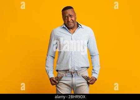 Sad mature african american man showing empty pockets Stock Photo