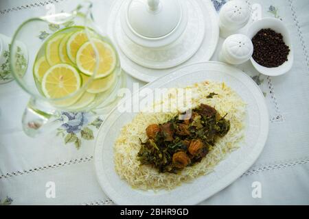 A bowl of white ceramic salt and pepper. Shah pilaf. Khan pilaf in a pita. Black pepper in a white ceramic pot . There is meat and plum chestnuts on Stock Photo