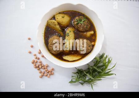 Traditional Azerbaijani Kufta bozbash - pea soup with lamb meatballs, made of minced meat and rice, zesty dried plum inside and boiled potatoes topped Stock Photo