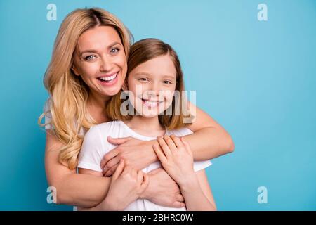 Photo of two people beautiful mommy lady little daughter blonds hugging best friends piggyback holding arms spend time together wear casual white s Stock Photo