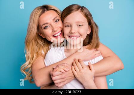 Closeup photo of two people beautiful mom lady little daughter hugging best friends piggyback holding arms spend time together wear casual white s Stock Photo
