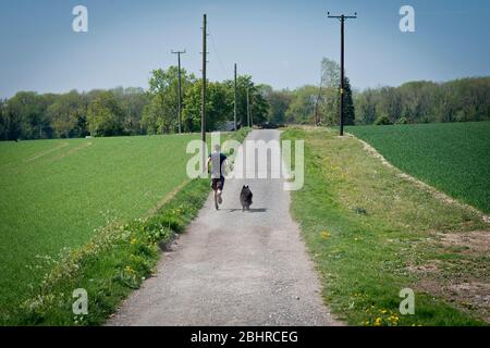 Man and dog on a run during Coronavirus lockdown daily exercise allowance Stock Photo