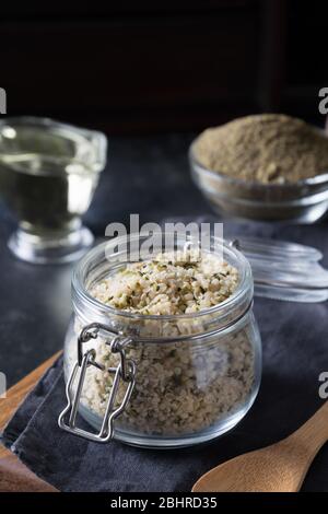 Organic kernels hemp in glass jar on black. Useful protein substitute for vegans and organic source of vitamins from safe varieties. Vertical format. Stock Photo