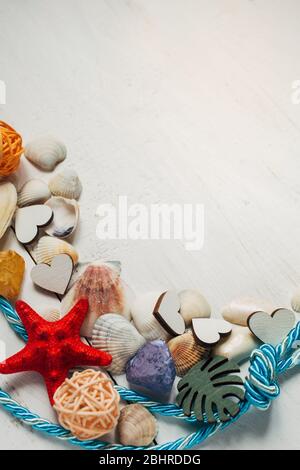Summer background. Different types of seashells, rope on wooden background. Stock Photo