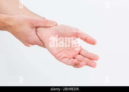 man's wrist hurts. A damaged female hand hurts. Hands suffer from work, sports injury. Sore spot is highlighted in red. Isolated white background. Stock Photo