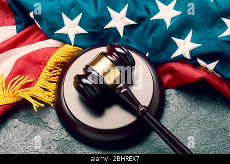 Judge's wooden gavel on background of American flag on black background in studio Stock Photo