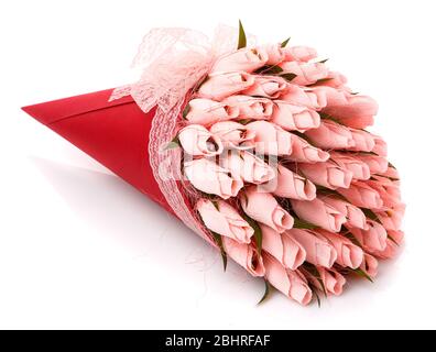 Pink tulips with candy inside made of corrugated paper in a red wrap with lace on a white background. Stock Photo