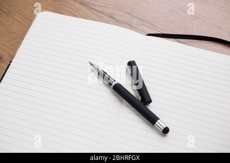 Empty Opened notepad with pen on wooden table Stock Photo