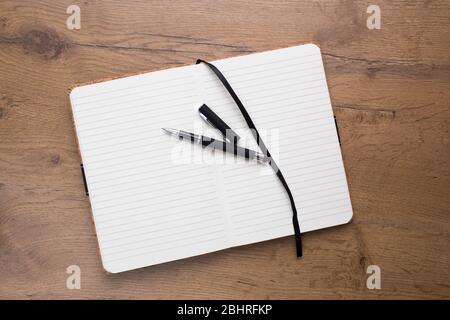 Empty Opened notepad with pen on wooden table Stock Photo
