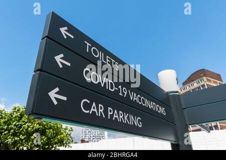 Sign pointing to COVID19 Vaccinations. Coronavirus COVID-19 Vaccine signpost. Corona virus vaccination finger post. Stock Photo